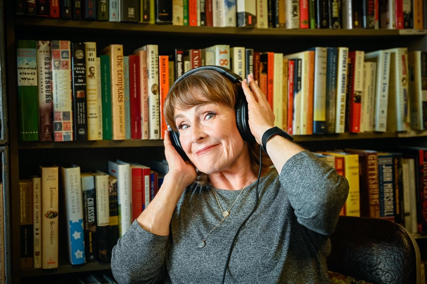 Becky Harding with headphones in a library.